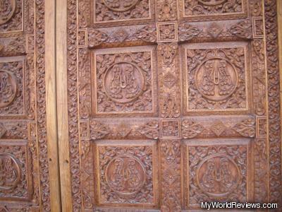 Part of a door at the entrance.  Even the door is covered with intricate patterns.