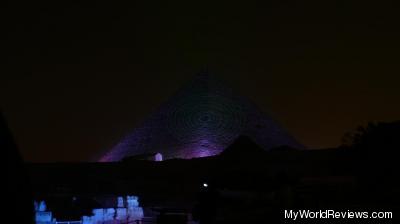 The great pyramid lit up in blue, with a laser effect on the front