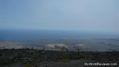 A lava field with a view of the ocean in the background